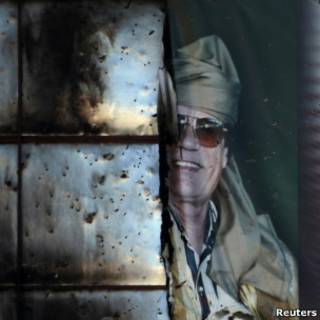 Banner semidestruído de Khadafi visto em prédio em Sirte (Reuters)