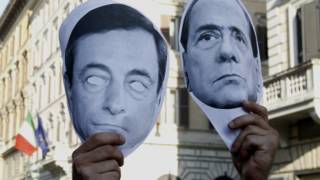 Mặt nạ hình ông Berlusconi (phải) bị trưng ra trong biểu tình phản đối trước Ngân hàng Quốc gia Ý