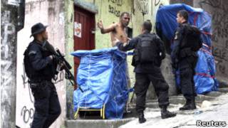 Policiais falam com morador da Rocinha ao subir o morro no domingo (Foto: Reuters)
