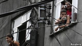 Moradores da Rocinha tiram foto durante ocupação da favela pela polícia (Foto: Reuters)