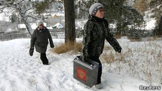Сотрудница избирательной комиссии с переносным ящиком для голосования