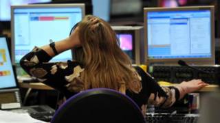Una mujer se agarra la cabeza frente a su computador