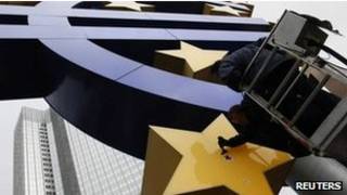 Homem retoca símbolo do Euro em Frankfurt. Reuters