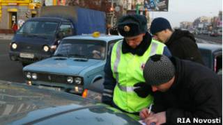 Российский полицейский оформляет протокол после ДТП в Омске