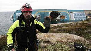 Integrante da equipe de resgate nas rochas em frente ao navio Costa Concordia (AP)