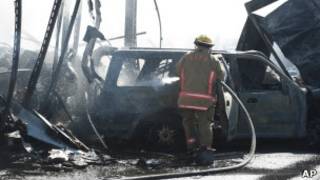 Bombeiro apaga carro incendiado em engavetamento na Flórida (AP)