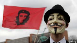 Ativista mascarado em protesto em Berlim. | Foto: Getty