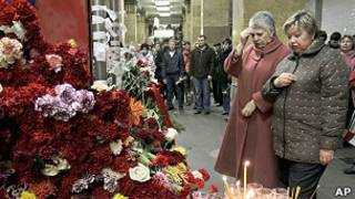 Женщины молятся рядом с цветами и свечами на перроне станции "Парк культуры"