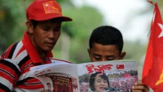 Người dân đọc báo có hình bìa là bà Aung San Suu Kyi