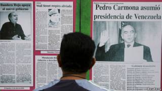 Hombre mira titurales de prensa en Venezuela tras el golpe del 11 de abril de 2002