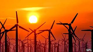 Un campo de turbinas de viento en la puesta del Sol