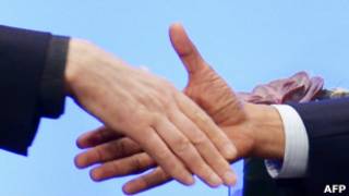Obama e o presidente afegão Hamid Karzai apertam as mãos. | Foto: AFP