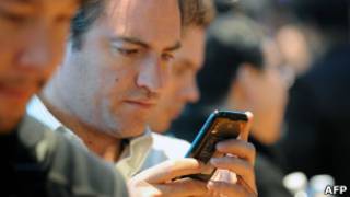 Homem usando smartphone (Foto AFP)