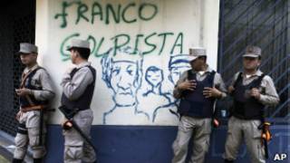 Policiais paraguaios em frebte a pixação contra Franco em Assunção