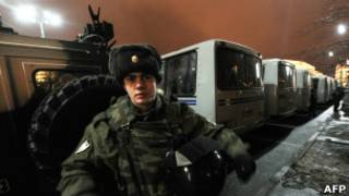 Полицейский на фоне автозаков