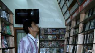 Покупатель в магазине рассматривает полки с DVD