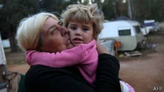 mulher com criança no colo (Foto: AFP)