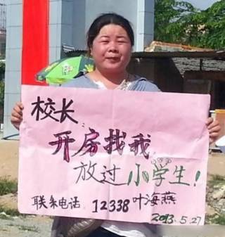 叶海燕举着“校长开房找我”标语牌的照片(网络照片)