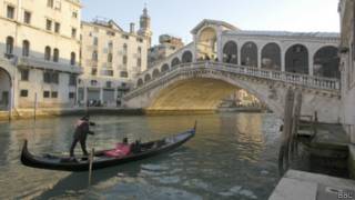 Gondoleiro na Ponte do Rialto, em Veneza | Foto: BBC