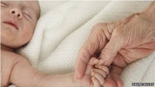 Bebe y mano de mujer mayor.