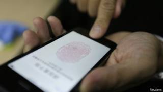 Dedo presiona el botón de inicio del nuevo iPhone 5S