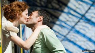 Una pareja se besa.