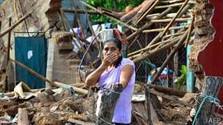 mujer entre las ruinas de su casa en Guerrero