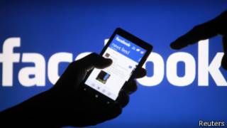 Пользователь смартфона показывает приложение Facebook