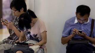 Chineses com seus tablets e smartphones em Pequim, em foto de arquivo (AP)