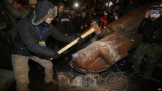 Manifestante golpeia estátua de Lenin na Ucrânia (foto: AP)