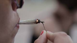 mulher acende cigarro de maconha