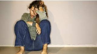 jovem sentada aparentando estar deprimida