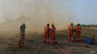 gas field workers oprating a driller