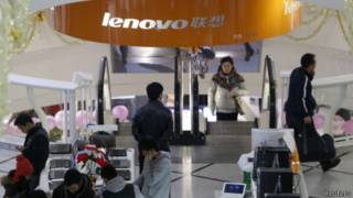 people stand under asign of Lenovo company