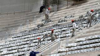 Operários ainda instalavam os assentos na arquibancada da Arena da Baixada, em Curitiba, no dia 21 de janeiro (AP)