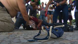 Cinegrafista da Rede Bandeirantes é socorrido após ser atingido por bomba (foto: BBC