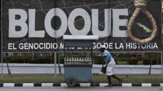 Vendedor passa em frente a propaganda contra o embargo americano a Cuba (foto: AP)