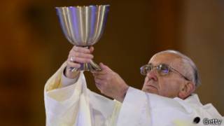 El papa Francisco alza la copa de la comunión.