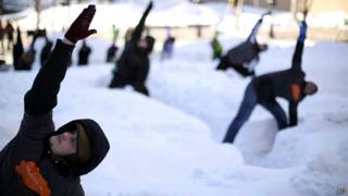 Personas hacen yoga en la nieve