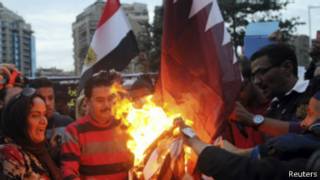 مصريون يحرقون علم قطر خارج سفارتها بالقاهرة