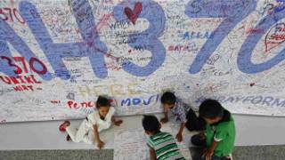 Crianças escrevem mensagens de apoio a passageiros e tripulantes de voo desaparecido MH3700, da Malaysia Airlines, no Aeroporto Internacional de Kuala Lumpur (Reuters)