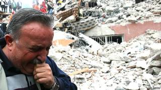 Un hombre frente a una montaña de escombros tra un terromoto en Turquía en 2011