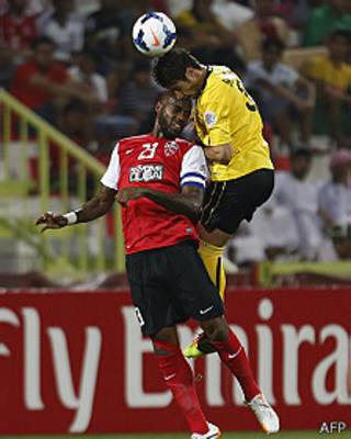 Dos futbolistas intentan cabecear el balón