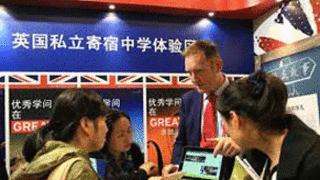 工作人员在2013中国国际教育展上为中国学生介绍英国私立寄宿中学的招生情况