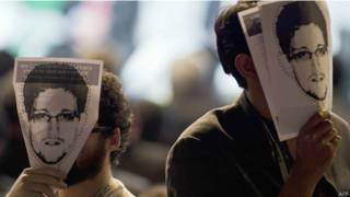 Participantes de conferência com máscaras de Edward Snowden