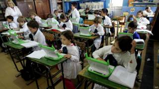 Crianças estudam com laptops no Uruguai, em foto de arquivo (AP)