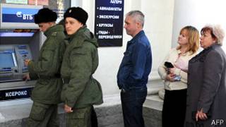 Soldados y civiles hacen cola para retirar dinero en un banco ruso en Crimea