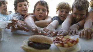 Niños ansiosos frente a comida rápida.