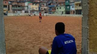 Meninos jogam futebol em campo de terra no Capão Redondo, em SP