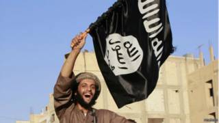 أحد أنصار الدولة الإسلامية يرفع علم التنظيم